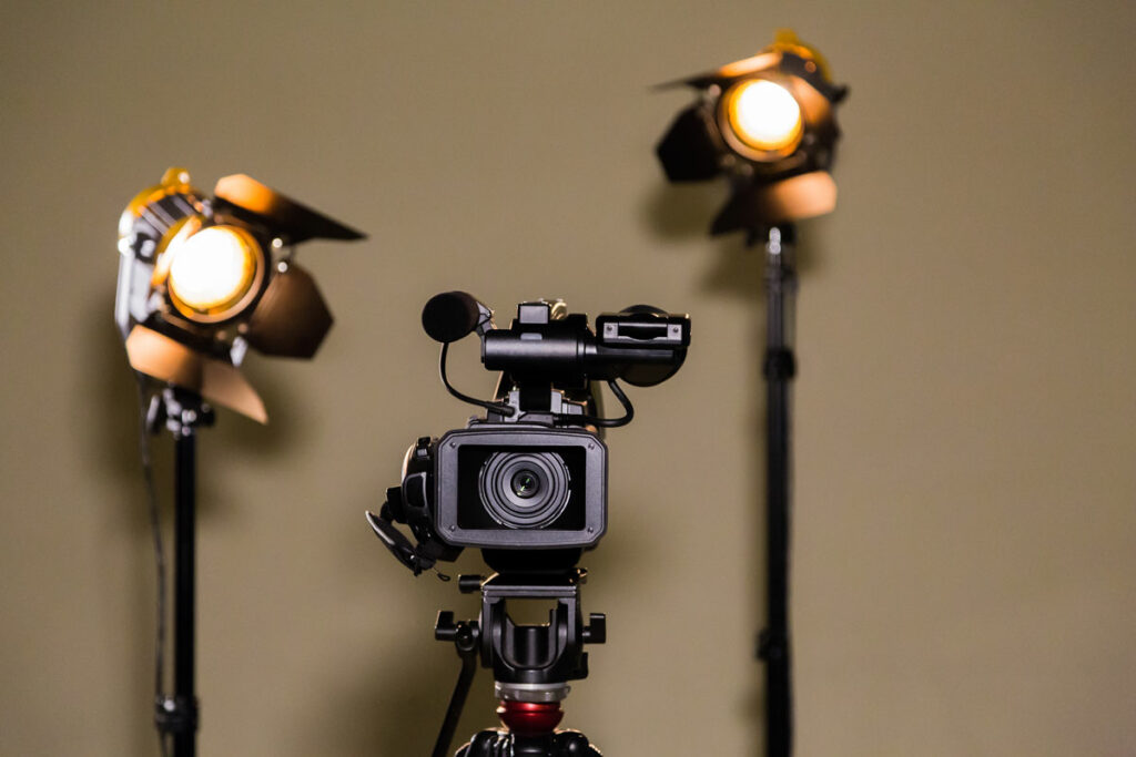 Video camera and lighting equipment against brown wall