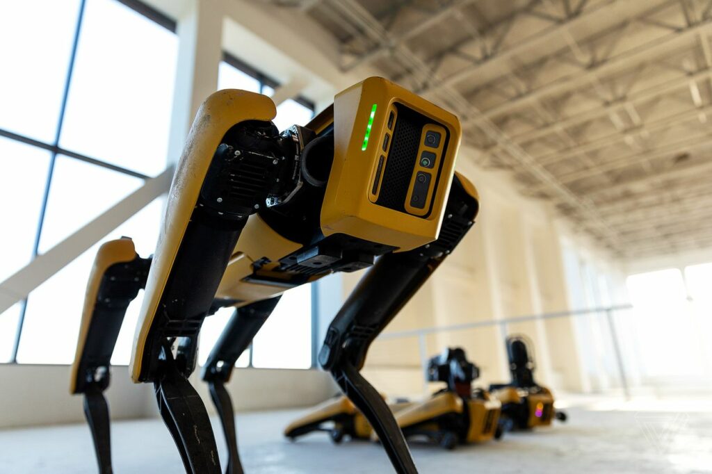 Black and yellow robotic dog in warehouse