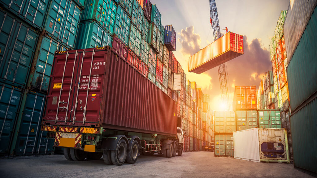 Shipping containers stacked up with truck and crane moving containers