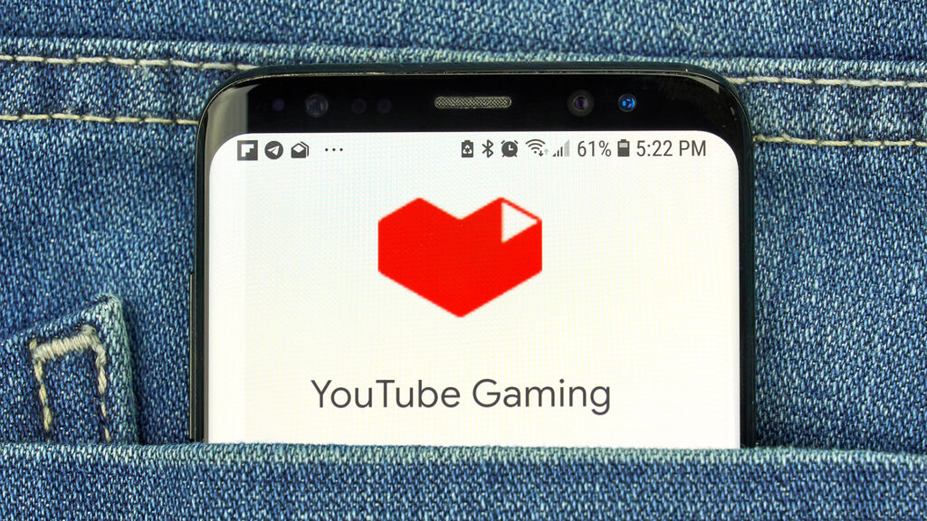 Smartphone in jeans pocket with YouTube gaming logo on screen