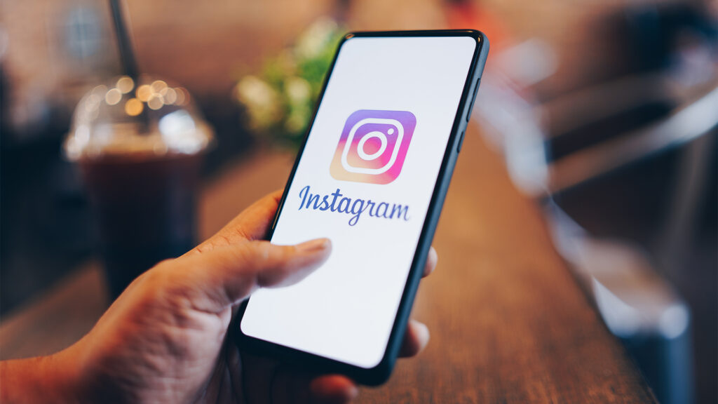 Person holding smartphone with Instagram logo on screen