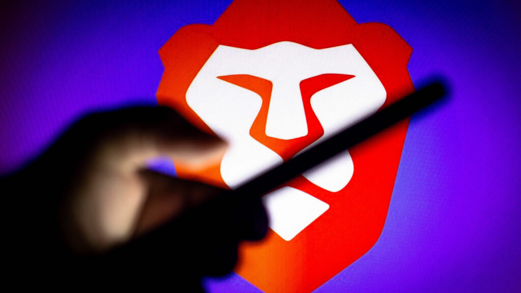 Person holding a smart phone with the Brave Search logo in background