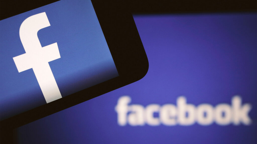 Smartphone with Facebook logo on screen and in background