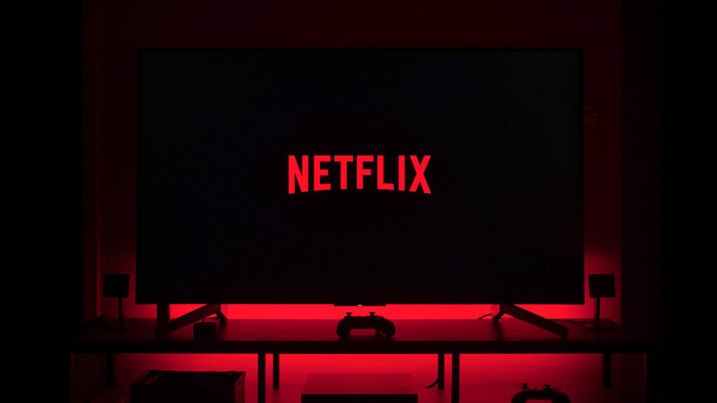 Tv with Netflix logo and gaming remote on table