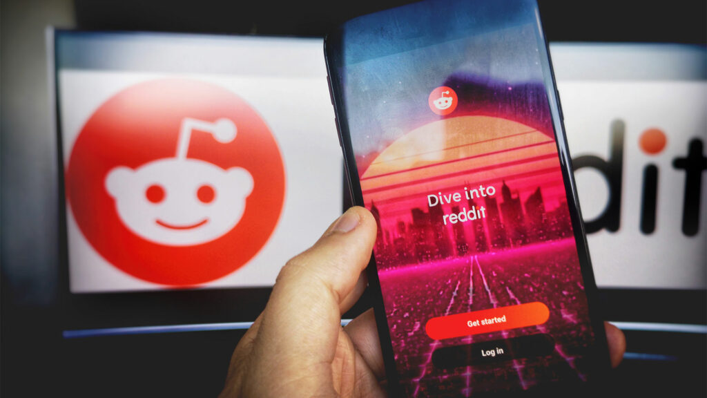 Smartphone with Reddit app and Reddit logo in background