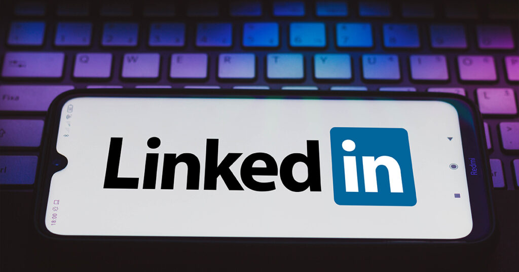 LinkedIn logo on smartphone resting against laptop keyboard