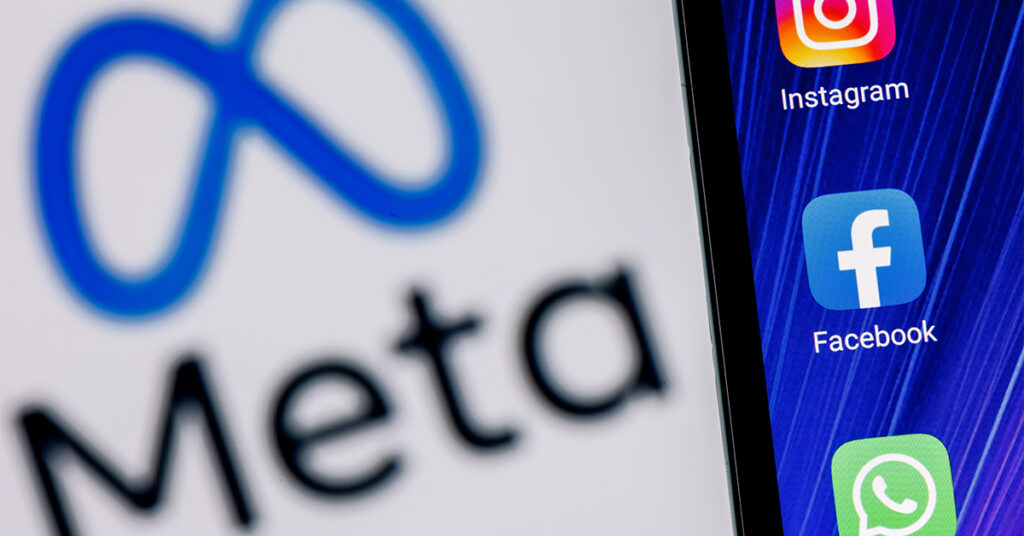 Cellphone with Meta logo and Facebook, Instagram and WhatsApp logo in the background