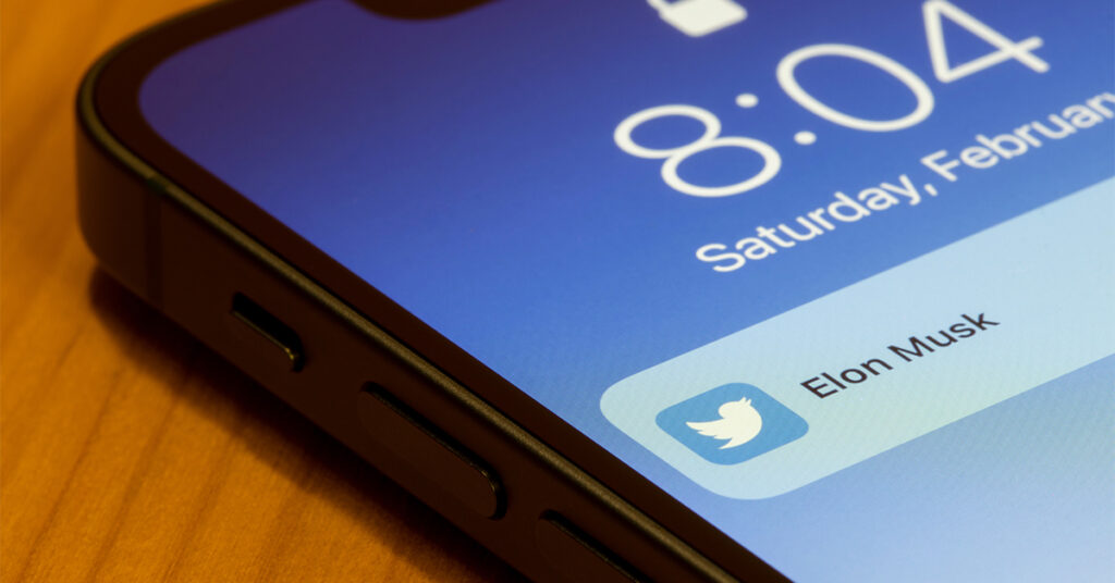Smartphone with Twitter notification and Elon Musk's name on screen