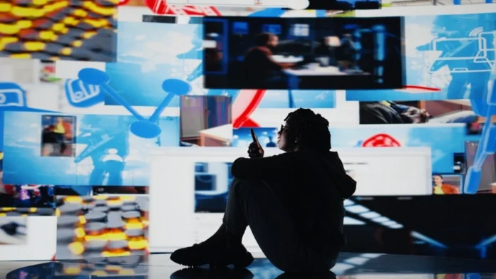Young teenager sitting on the floor scrolling though social media while surrounded by social media posts.