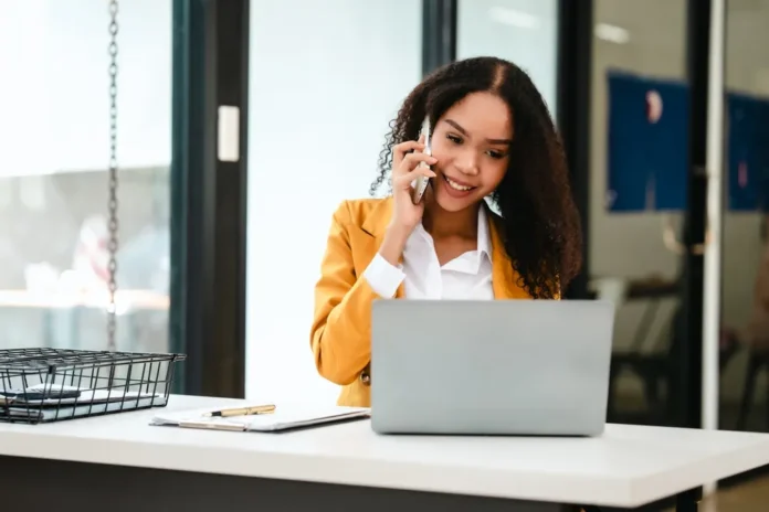 Young business woman on the phone and her laptop.